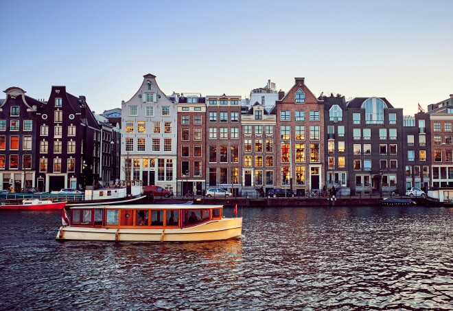 Wooden boat on the canal  and old buildings in Amsterdam