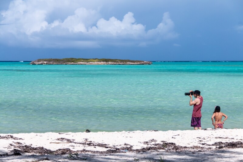 Tourists enjoy the white sand and crystal clear Caribbean waters of Bambarra Beach in the Turks and Caicos Islands.