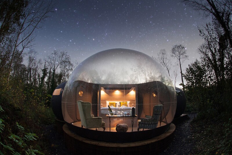 A bubble dome at Finn Lough at night among trees