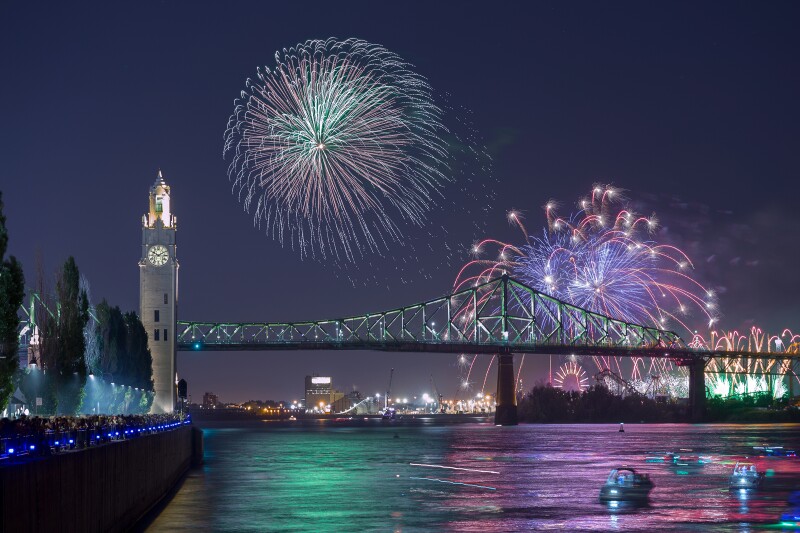Fireworks in the sky over a river and a bridge during Montréal’s annual summer fireworks competition.