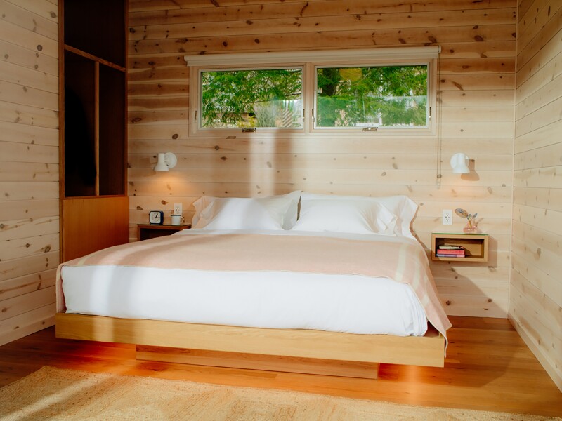A large bed in white linens inside a private cabin at Prospect hotel