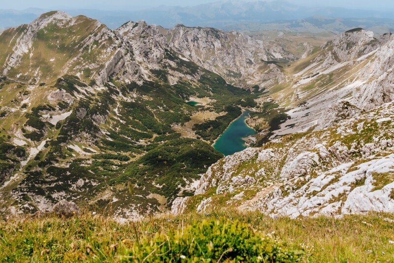 A lake and valley surrounded by mountain peaks