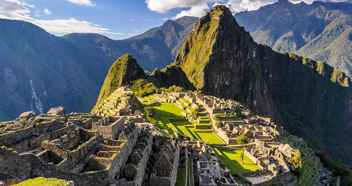 Golden sun rolls in across the ruins of Machu Picchu