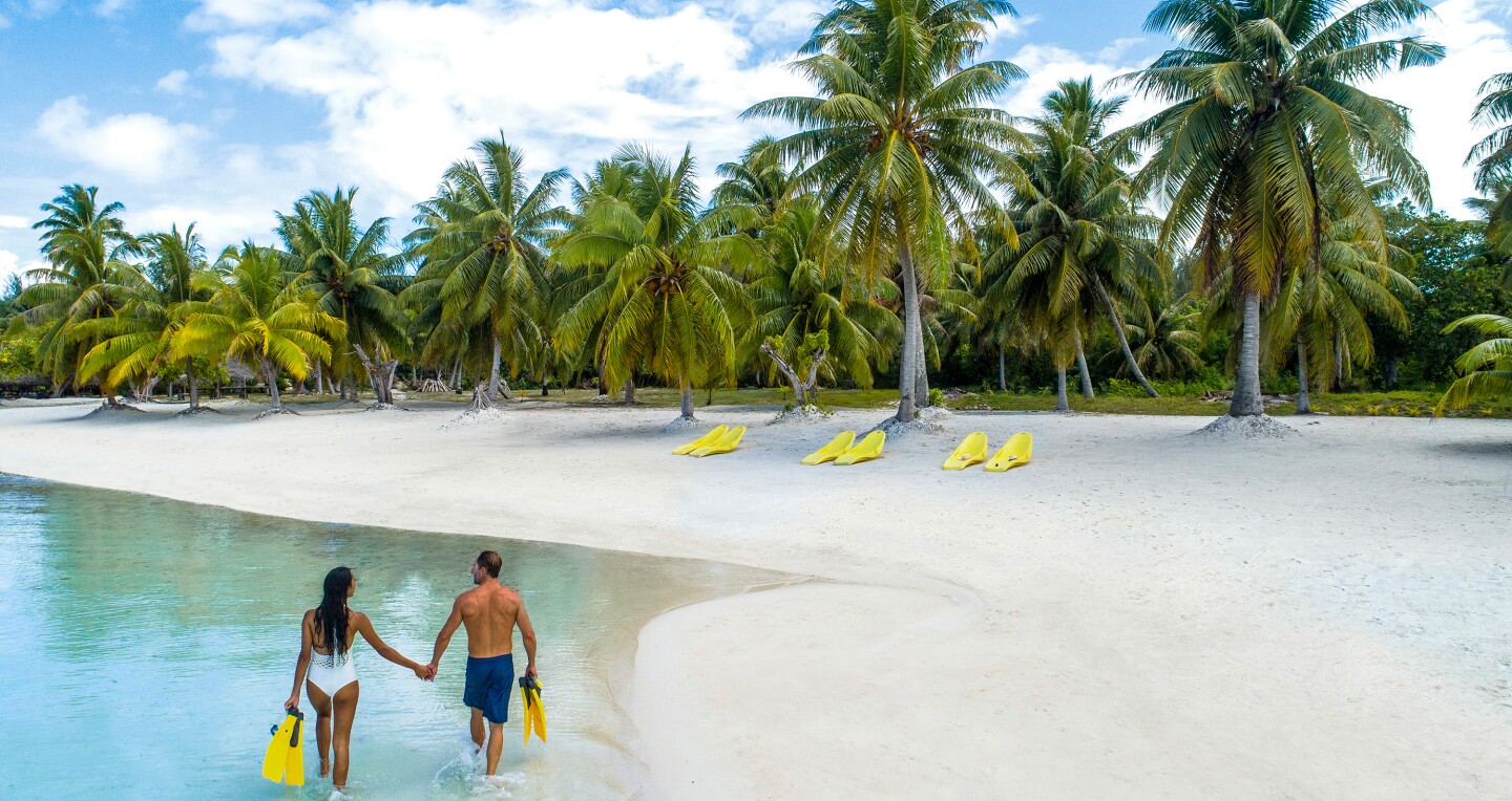 Couple on walking on the beach in Bora Bora