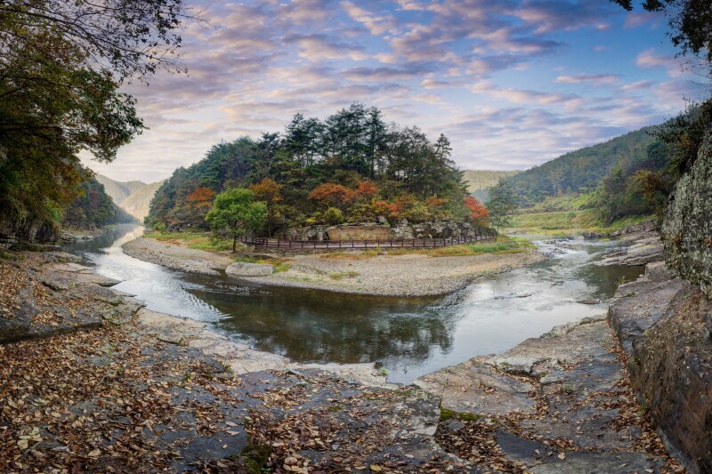 The U-shaped stretch of the Bangucheon Stream in South Korea, with an island in the middle that has rocks and trees
