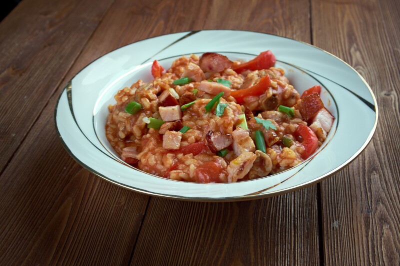 White plate with rice, peppers, and green onions inside
