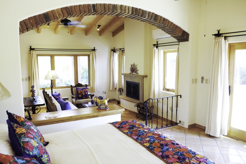 Bedrooms at Rancho La Puerta feature an overall white aesthetic with color accents on pillows and throws.