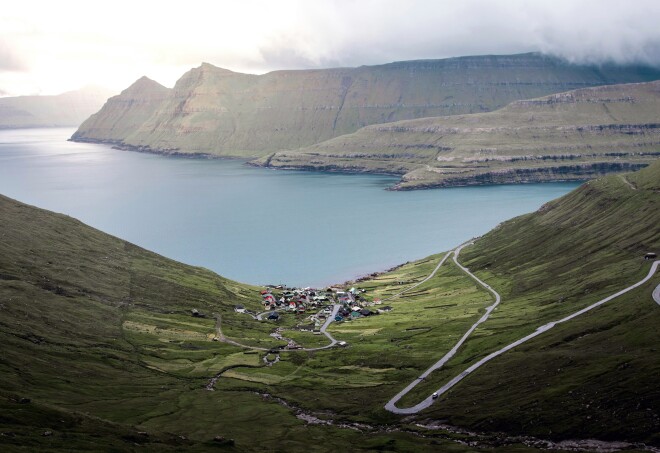 winding road with view of bay and small village