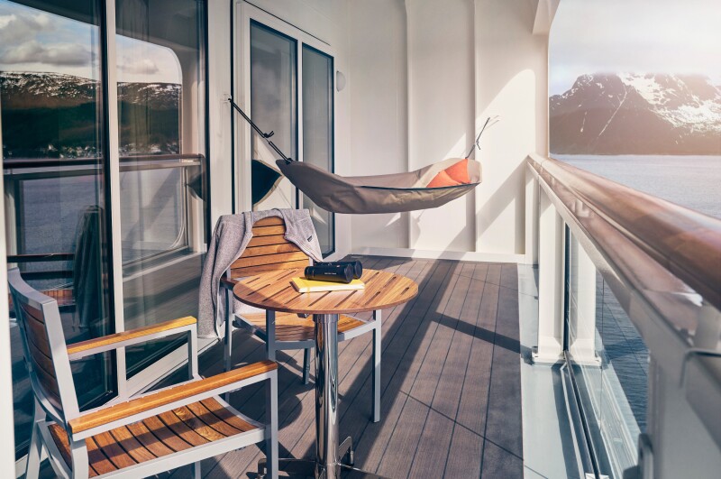 The balcony area on the National Geographic Endurance expedition ship with two chairs and a small table and a hammock