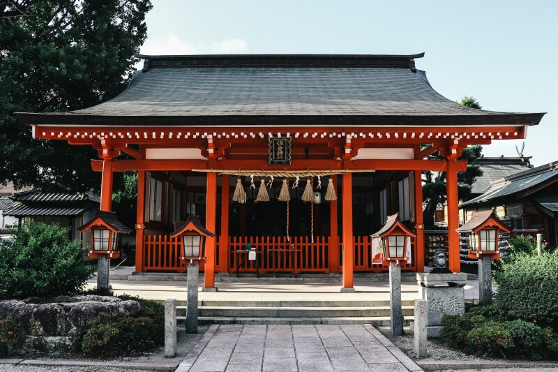 A small, traditional red Shinto shrine in Fukuoka