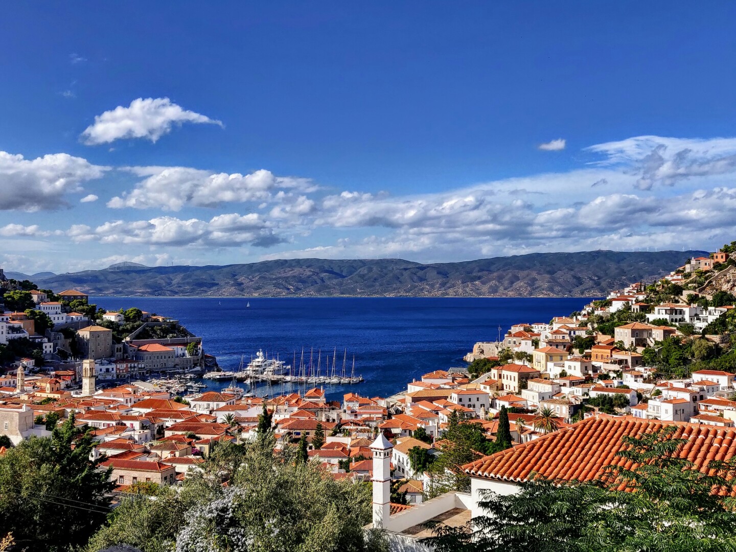 Red-tiled roofs around a bay with mountains in the background