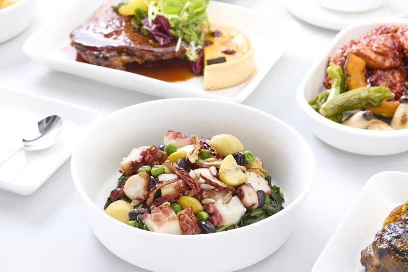 White bowl of stir-fried octopus, with pork on white plate