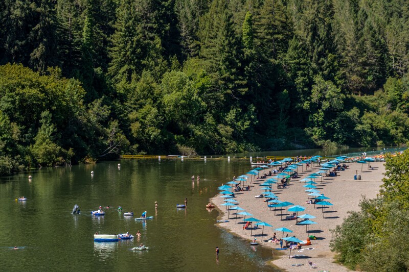 Beach scene with colorful umbrellas at Johnson's Beach, Guerneville, California, on the Russian River.