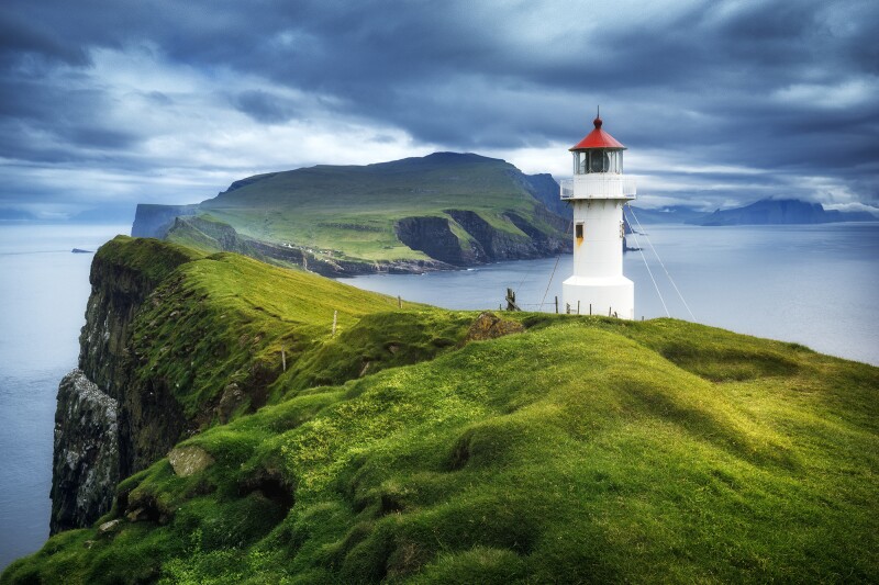 Green Mykines Island in the Faroe Islands, with short white lighthouse
