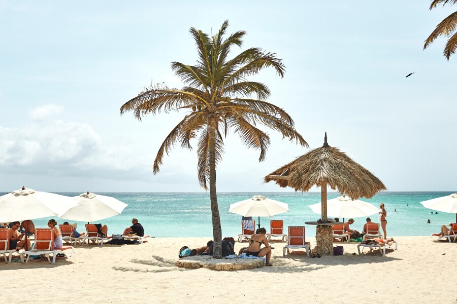 People sitting underneath beach umbrellas on a beach