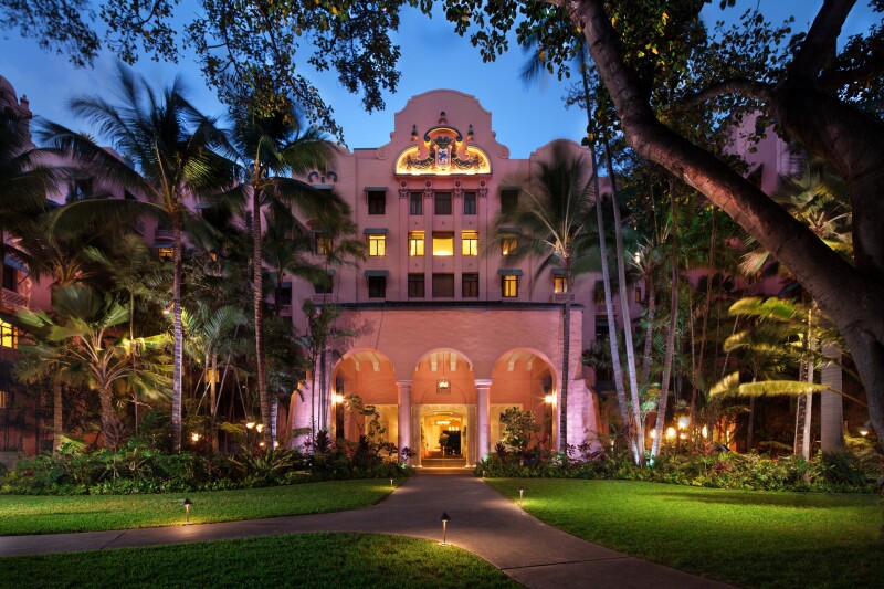 Exterior of the pink Royal Hawaiian hotel at night