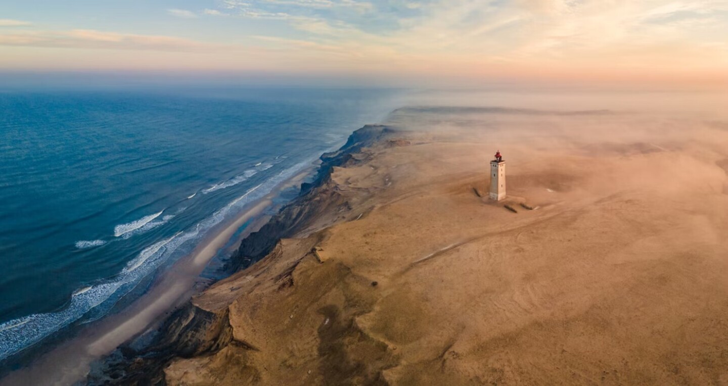 A lone lighthouse in a desert by the sea