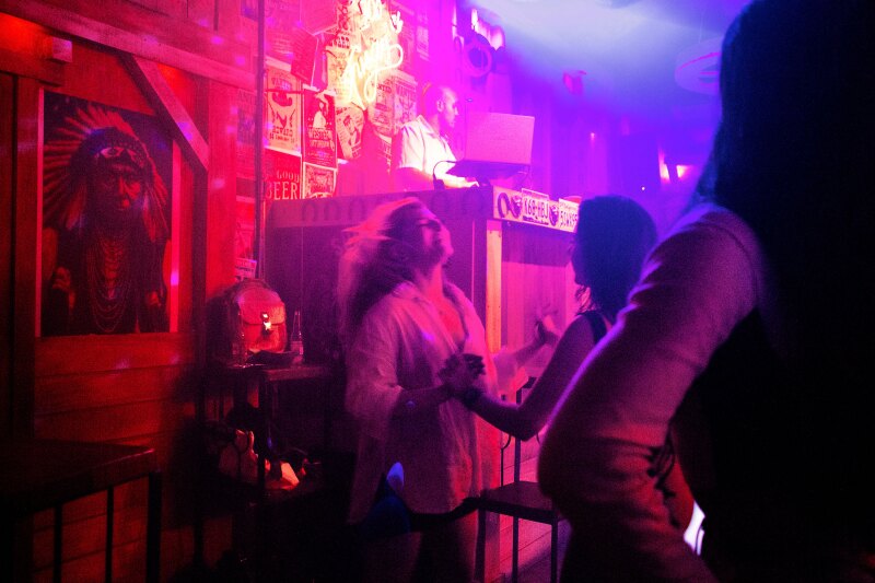 Two people dance in the hot-pink lights of a club, Teatro Victoria, Provenza, Medellín