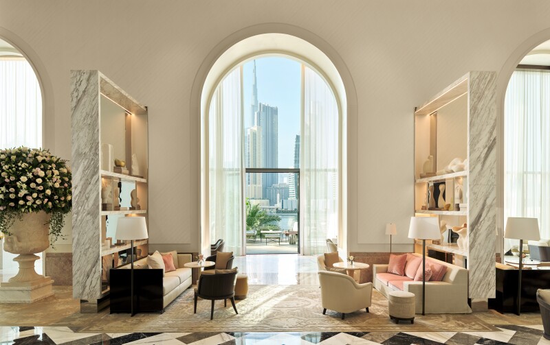 The lobby at the Lana faces Dubai's skyline, with high arched windows leading to outdoors