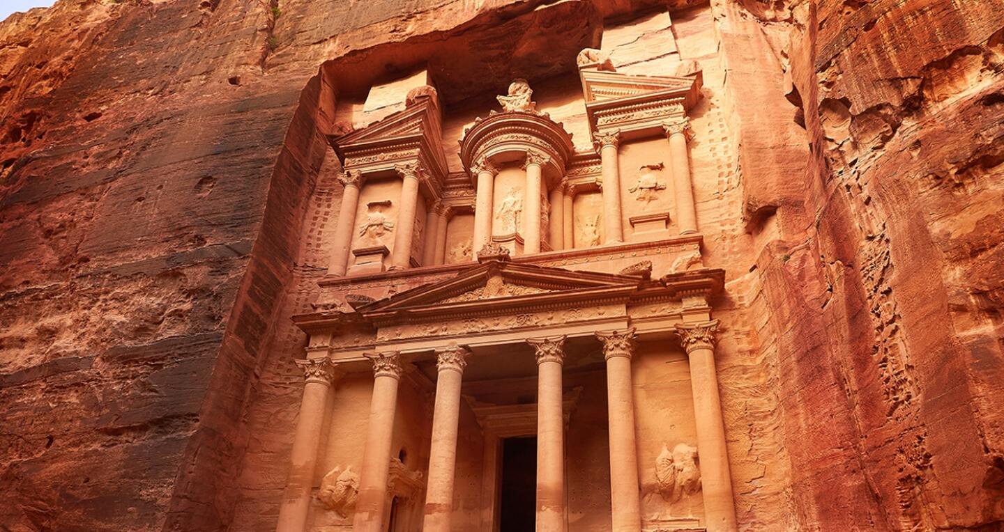 A detailed palace facade carved into red rock