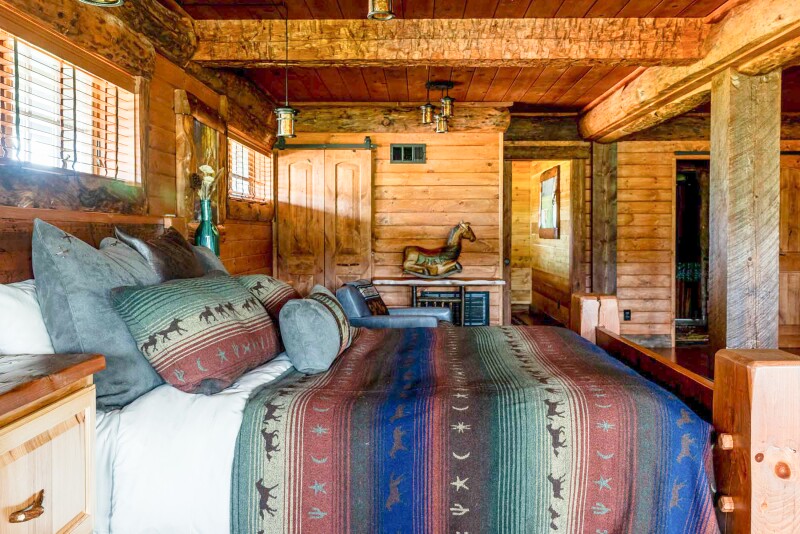 This guest room at Driftwood Ranch Resort has wood walls and an animal- patterned throw on the bed.