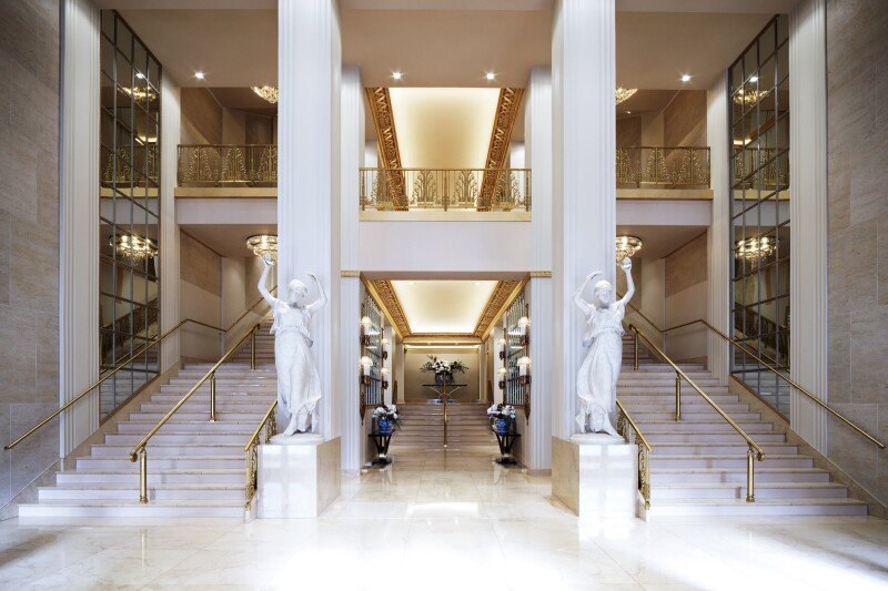 The Lexington Avenue entrance of Waldorf Astoria New York features two white statues and two large staircases.
