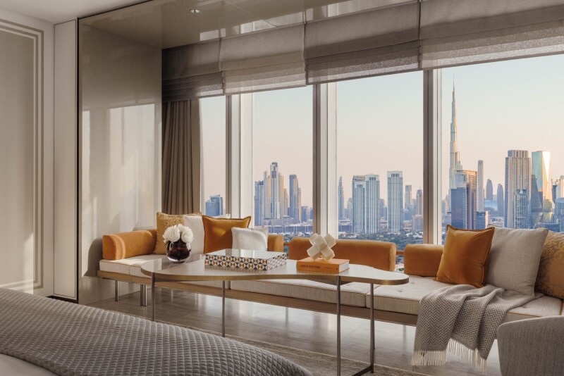 A Za'abeel King room has a long seating area with pillows next to floor-to-ceiling windows that face Dubai's skyline.