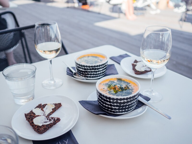 Two bowls of salmon soup on a white table cloth at Löyly, a sauna restaurant by the Baltic Sea
