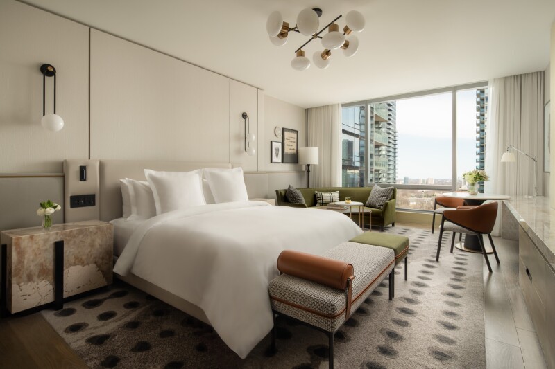 A guest room at the Four Seasons Hotel Toronto with a large bed and picture windows