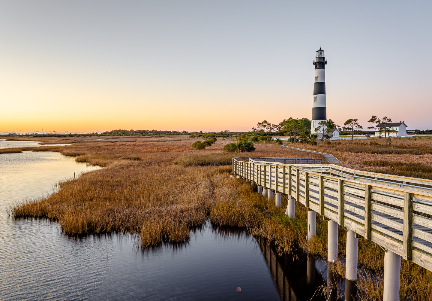 Black and white striped lighthouse on boggy ground near water