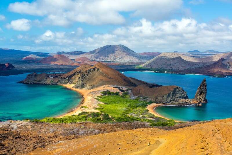 View of two beaches on Bartolome Island in the Galapagos Islands in Ecuador with mountains in the backdrop