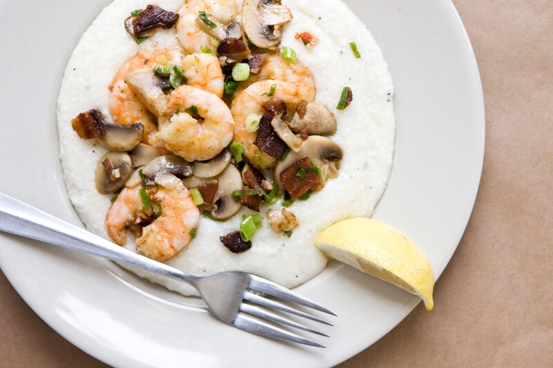 Shrimp and mushrooms over white grits in a plate