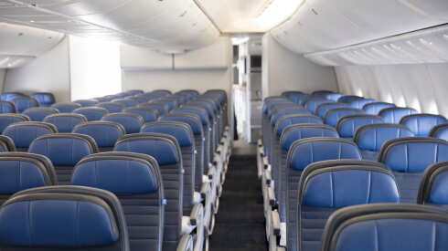 Images of empty economy class seats with blue headrests on a United Airlines airplane