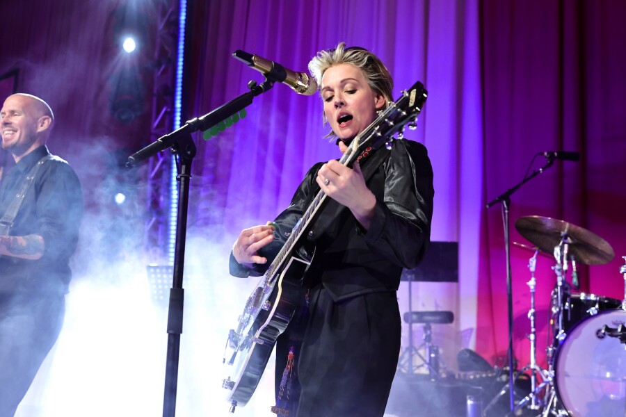 Brandi Carlile, dressed in black with black guitar, onstage during the Elton John AIDS Foundation's 30th Annual Academy Awards Viewing Party in 2022