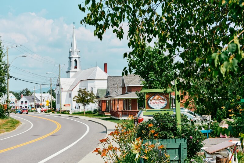 Curving road alongside a white church and house-like buildings