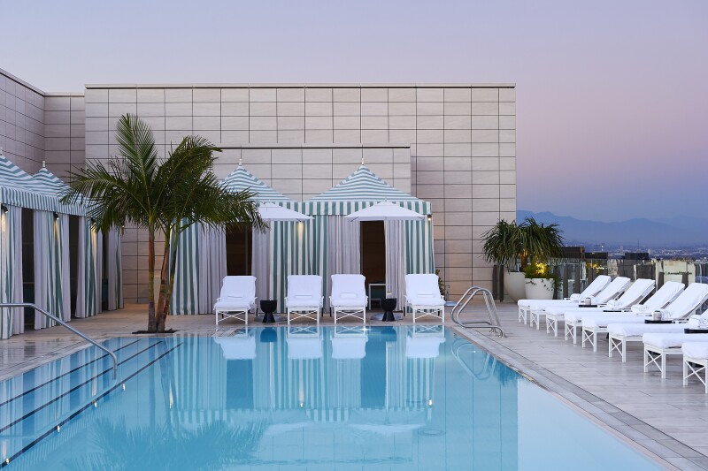 Waldorf Astoria Beverly Hills rooftop pool with green-striped cabanas