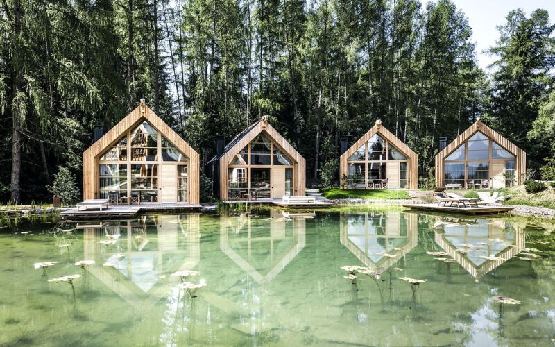 Adler Lodge Ritten is composed of A-frame chalets built with wood.
