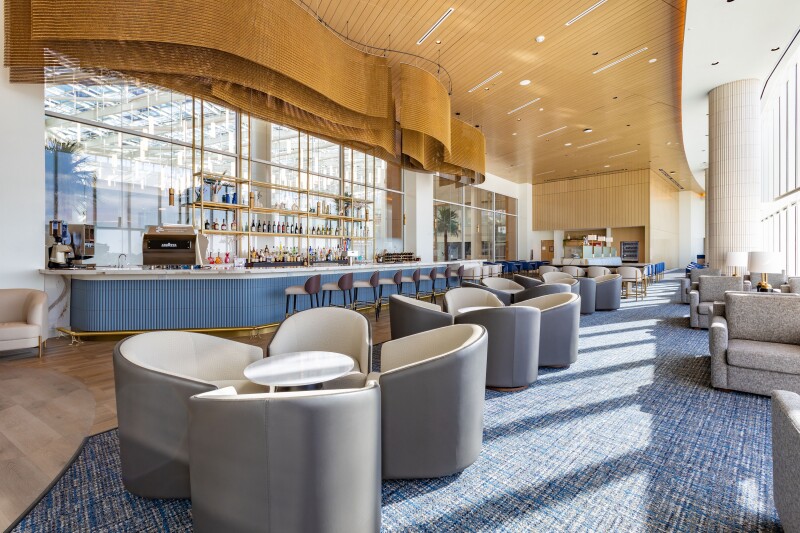 The bar area of the Plaza Premium lounge at Orlando International, with rounded modern chairs in foreground