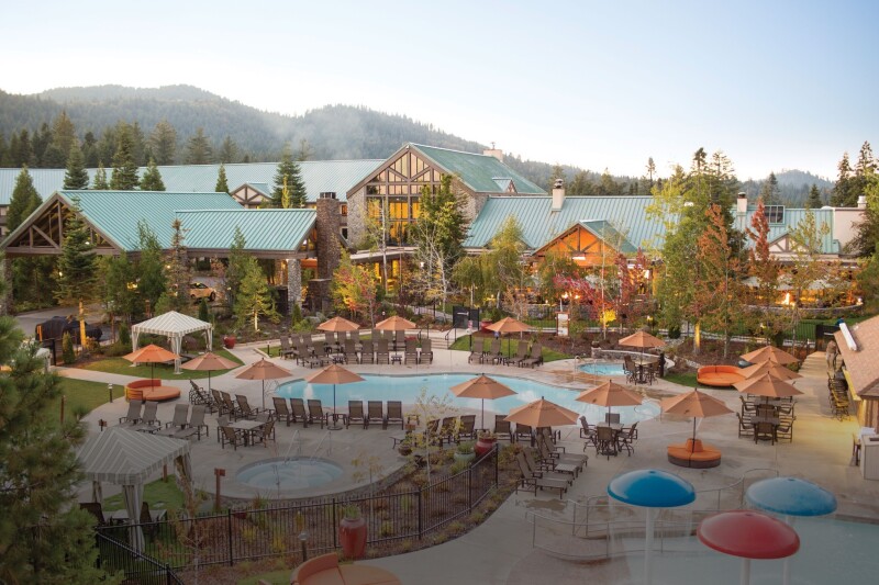 Aerial view of large lodge with pools and hot tub in foreground