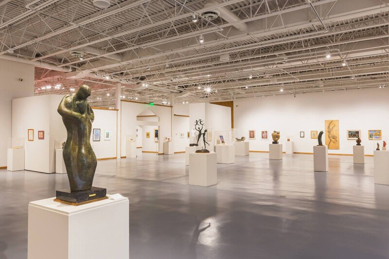 Widely spaced sculptures and paintings inside the Nicolaysen Art Museum in Casper