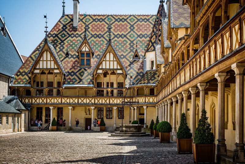 The 15th-century Hospices de Beaune, a former hospital turned museum, features Gothic architecture and an intricately tiled roof.