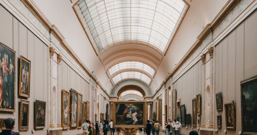 An interior gallery of the Louvre Museum in Paris with people milling about