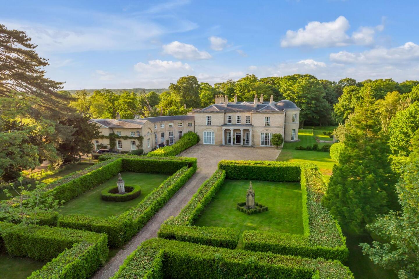 نمای هوایی از نمای بیرونی عمارت با باغ های رسمی انگلیسی در پیش زمینه