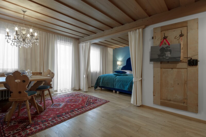 Hotel La Perla's guest rooms have wooden floors, red carpeting, and chandeliers.