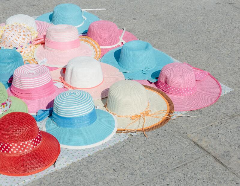 Kitschy sun hats lay out for sale on the streets.