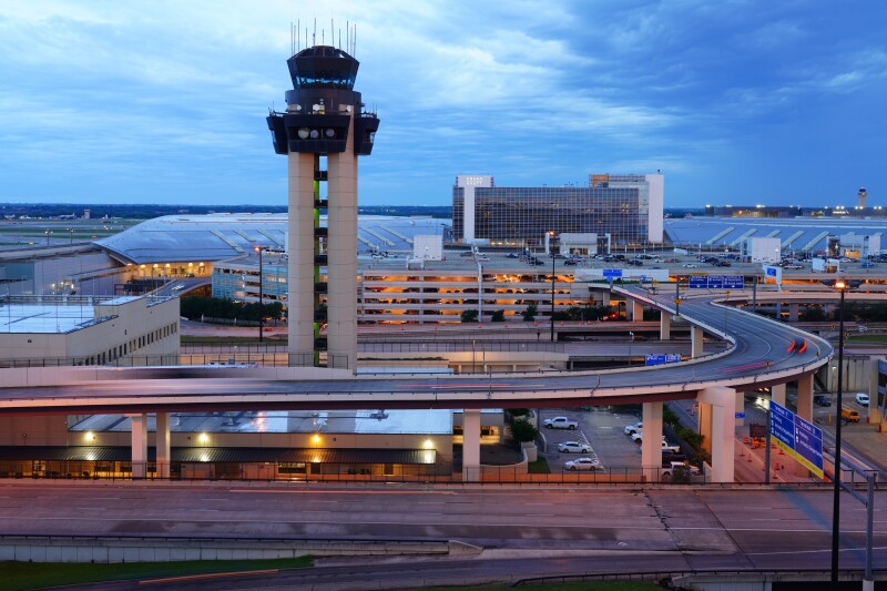Exterior view of Dallas Fort Worth International Airport with control tower and roads lead to and along the airport