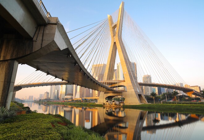 a view of the X-shaped Octavio Frias de Oliveira bridge  with the skyline of Sao Paulo Brazil in the background