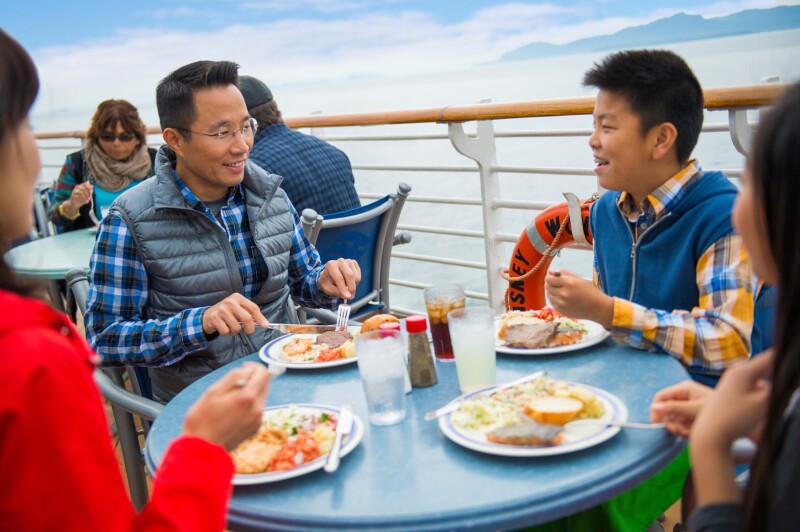 A family eating a meal in the deck of a Disney Cruise Line ship.