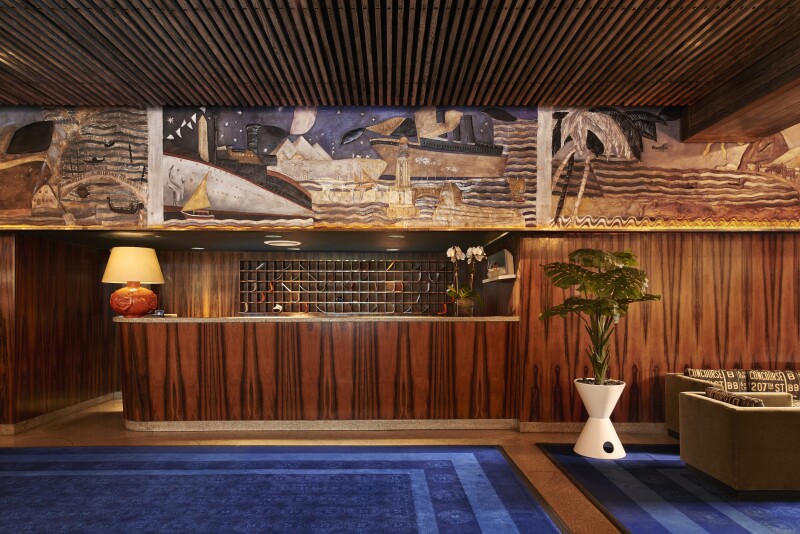 The reception area at the Maritime Hotel has dark wood paneling and a dark blue carpet.