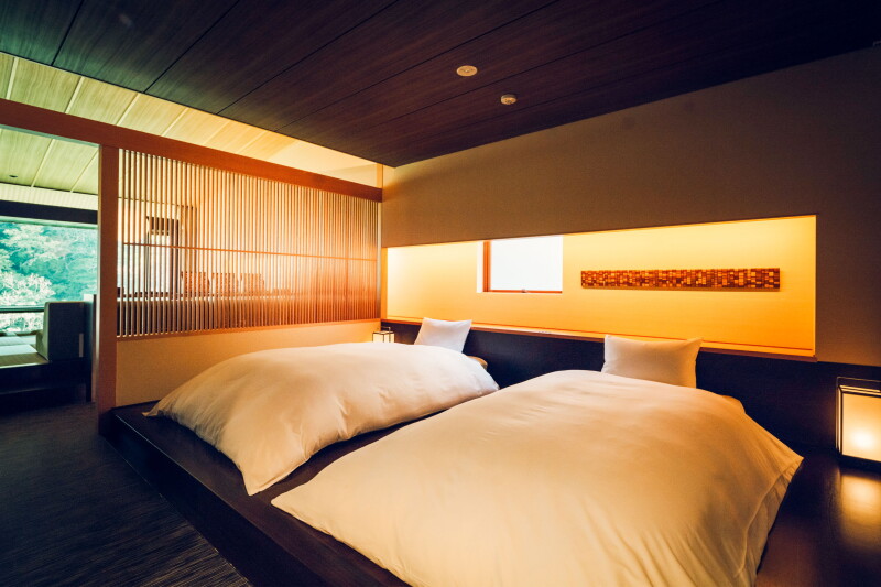 A guest room at Kai Hakone with two Western-style beds and a wooden room divider with slats